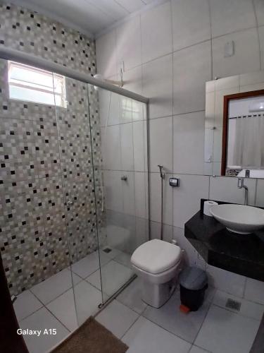 a bathroom with a shower and a toilet and a sink at Pousada Portal do Peruaçu in Januária