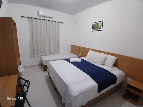 een hotelkamer met twee bedden en een raam bij Pousada Portal do Peruaçu in Januária