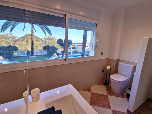 La salle de bains est pourvue d'une baignoire, d'une fenêtre et de toilettes. dans l'établissement Villa Puerto de la Luz, à Mijas