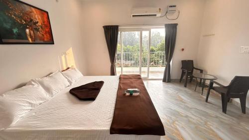 une chambre avec un lit, une table et une fenêtre dans l'établissement La Nature Retreat, à Kuilapayam