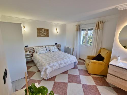 une chambre avec un lit et une chaise jaune dans l'établissement Villa Puerto de la Luz, à Mijas