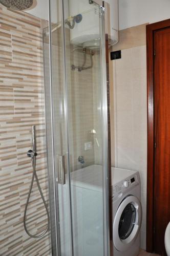 a bathroom with a shower and a washing machine at Viale Repubblica 307 4 in Pietra Ligure
