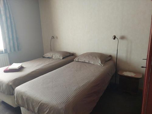 twee bedden in een hotelkamer met rokken bij Logerenbijonsz in Berghem