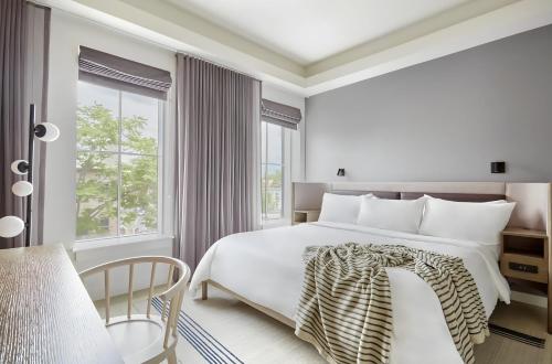 a bedroom with a white bed and a window at Lark Hotels 907 Main in Cambridge