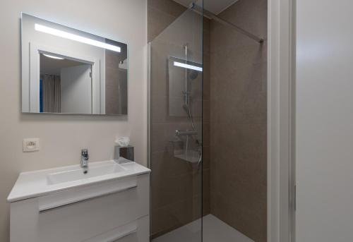 a bathroom with a sink and a shower with a mirror at X-Corner Ostend - Casselbergh Residences in Ostend