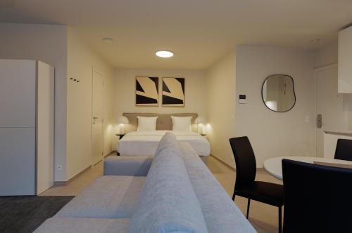 a hotel room with two beds and a desk at X-Corner Ostend - Casselbergh Residences in Ostend