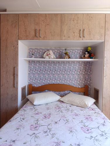 a bedroom with a bed with a floral headboard at Condomínio Sol de Verao in Florianópolis