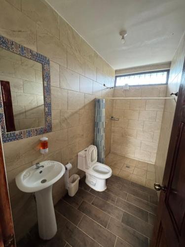 a bathroom with a toilet and a sink at Hotel El Alero in Chimaltenango
