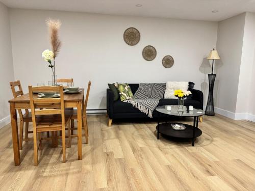 un soggiorno con un divano nero e un tavolo di New Modern Private Suite Near Champlain Mall a Moncton