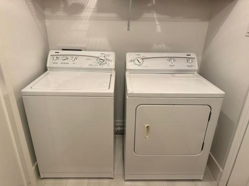 due elettrodomestici bianchi seduti uno accanto all'altro in una cucina di New Modern Private Suite Near Champlain Mall a Moncton
