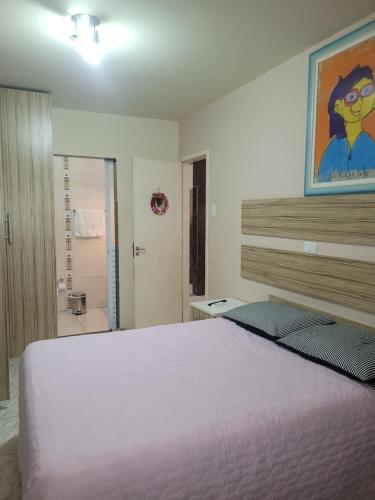 een slaapkamer met een groot wit bed en een badkamer bij Casa com 3 Quartos Enseada Encantada in Porto Belo