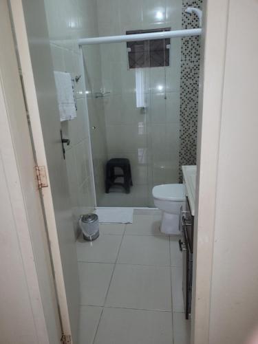 een witte badkamer met douche en toilet bij Casa com 3 Quartos Enseada Encantada in Porto Belo