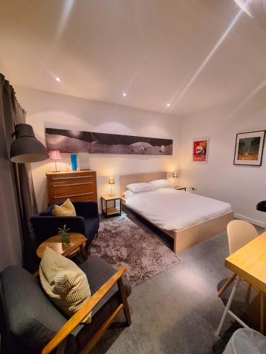 a bedroom with a large bed and a couch at the icecream factory, room in private house in York