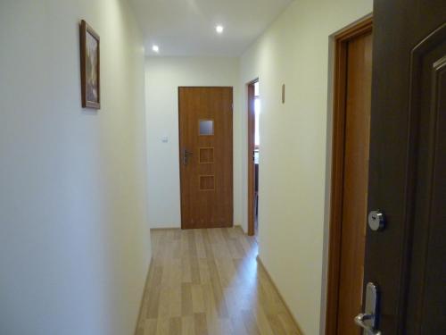 an empty hallway with a door and a wooden floor at Energy House in Jasło
