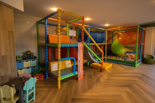 a play room with a slide and play equipment at Hotel Portinari Centro in Foz do Iguaçu