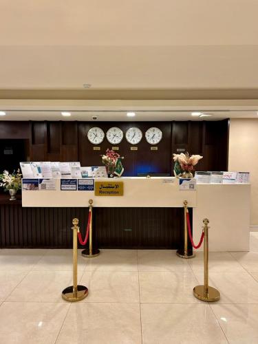a lobby with a counter with clocks on the wall at Mdmak Suites in Riyadh