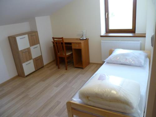 a bedroom with a bed and a desk and a chair at Energy House in Jasło