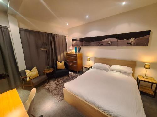 a bedroom with a large white bed and a desk at the icecream factory, room in private house in York