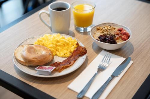 un tavolo con un piatto di prodotti per la colazione e una tazza di succo d'arancia di Courtyard Bristol a Bristol