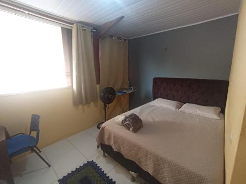 a bedroom with a bed and a chair and a window at kit Net B in São Luís