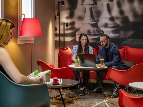 un gruppo di persone sedute a un tavolo con un computer portatile di ibis Gap Centre a Gap