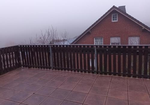 una staccionata di legno davanti a una casa di Ferienwohnung DFranz a Weitefeld