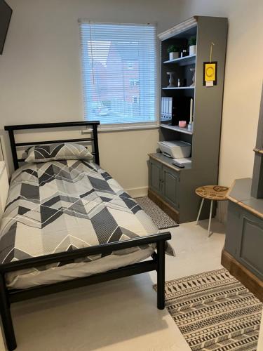 een slaapkamer met een bed, een bureau en een raam bij The White House in High Ackworth