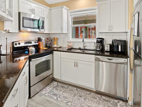 une cuisine avec des armoires blanches et des appareils électroménagers blancs dans l'établissement OYD3 - Las Palmas 2, à Kill Devil Hills