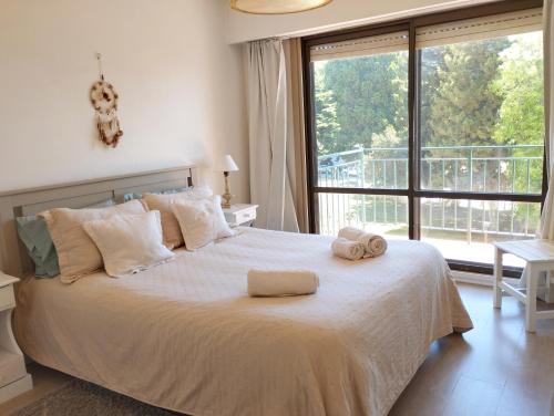 ein Schlafzimmer mit einem großen Bett mit zwei Handtüchern darauf in der Unterkunft Cuatro Estaciones in San Carlos de Bariloche