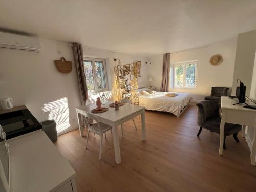 ein Wohnzimmer mit einem Bett und einem Tisch in der Unterkunft Studio au dernier étage d'une bastide grassoise in Grasse
