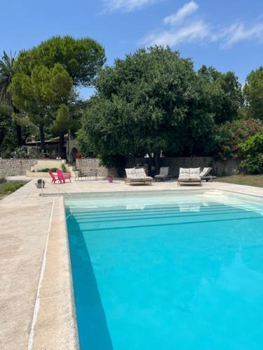 ein großes Schwimmbecken mit blauem Wasser in der Unterkunft Studio au dernier étage d'une bastide grassoise in Grasse