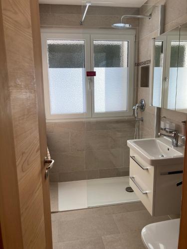 a bathroom with a shower and a sink at Ferienwohnung Haus Ginseng in Davos