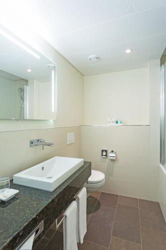 a white bathroom with a sink and a toilet at Hotel St.Gotthard in Zürich