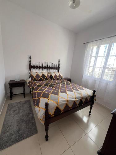 een slaapkamer met een bed in een kamer met een raam bij Latin House in Funchal