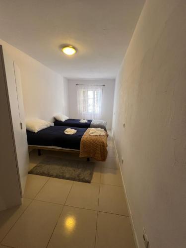 een kleine slaapkamer met een bed en een raam bij Latin House in Funchal