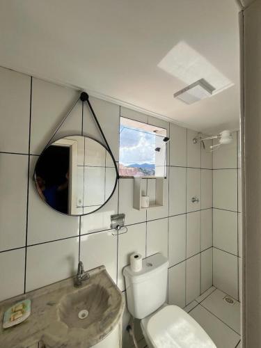 a bathroom with a toilet and a sink and a mirror at kitnet Nostradamus in Barão de Cocais
