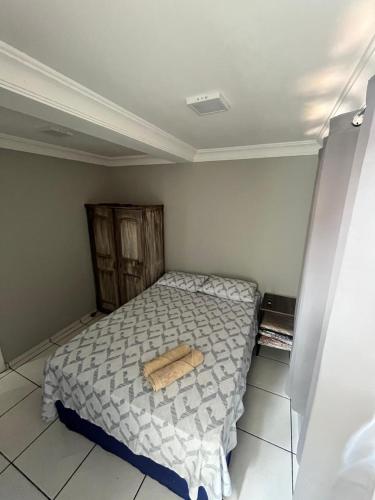 a bedroom with a bed with a wooden object on it at kitnet Nostradamus in Barão de Cocais