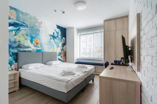 een slaapkamer met een bed en een bureau met een televisie bij Aquapark Reda Resort - jedyne noclegi w Aquaparku Reda in Reda