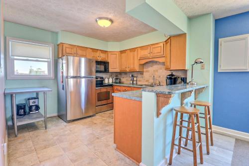 a kitchen with wooden cabinets and a stainless steel refrigerator at SO1A - Shangri-La in Kill Devil Hills