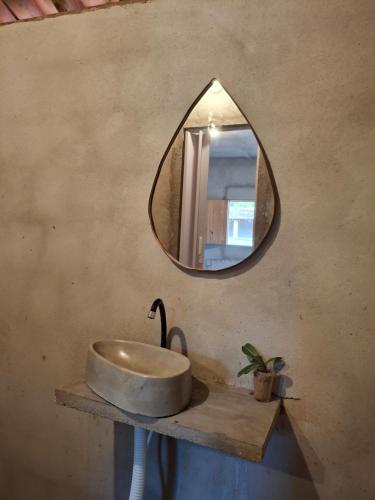 a bathroom with a sink and a mirror on the wall at Yahweh Guriú in Camocim