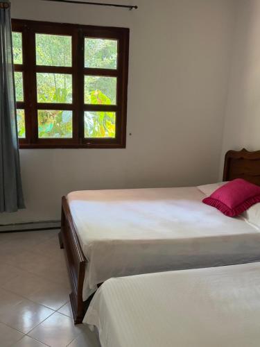 due letti in una stanza con finestra di cabaña grande ecopolis hospedaje a El Queremal