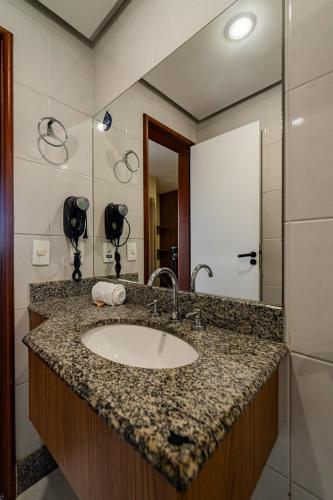 a bathroom with a sink and a mirror at Nobile Suites Diamond in Vitória
