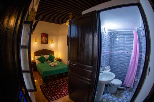 a room with a bed and a bathroom with a toilet at Shauala Riad - Where History Lives in Fès
