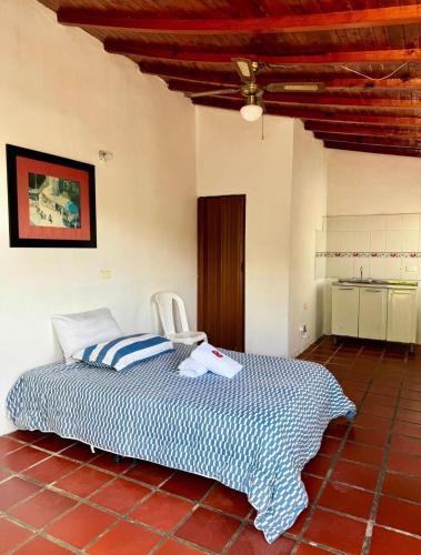 a bedroom with a bed and a chair in a room at Ecohotel Los Cedros in Cocorná
