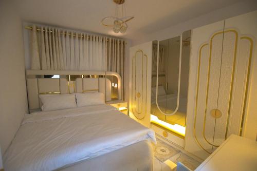 a bedroom with a white bed and a window at Golden Apartment Korce in Korçë