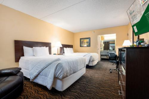 a hotel room with two beds and a television at MCM Grande FunDome Odessa in Odessa