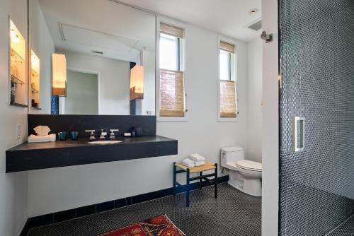 un bagno con lavandino, specchio e WC di Hotel Saint Cecilia ad Austin
