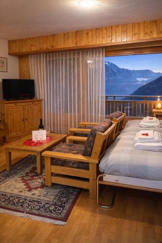 a bedroom with a bed and a balcony with a view at Alpstay - Résidences des Bains d'Ovronnaz - Studio SUD S204 in Ovronnaz