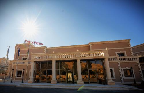 ein Gebäude auf einer Straße mit der Sonne dahinter in der Unterkunft Petra Pillars Luxury Hotel in Petra