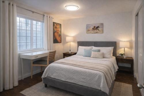 a bedroom with a bed and a desk and a window at The Olympic Suites LA in Los Angeles